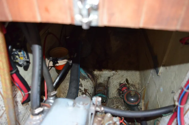 Slide: The Image of Engine compartment of a 1982 Young Sun Cutter sailboat, showing hoses and mechanical components. - 27