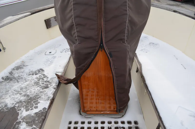 Slide: The Image of 1982 Young Sun Cutter sailboat cockpit with snow-covered deck and protective cover. - 28