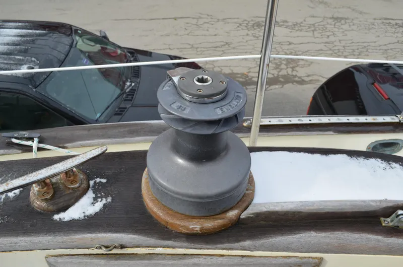 Slide: The Image of 1982 Young Sun Cutter sailboat winch on deck with snow and nearby parked cars. - 31