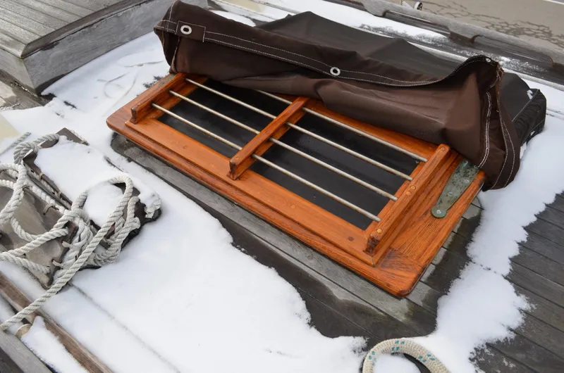 Slide: The Image of Wooden hatch on 1982 Young Sun Cutter, covered in snow with ropes nearby. - 38