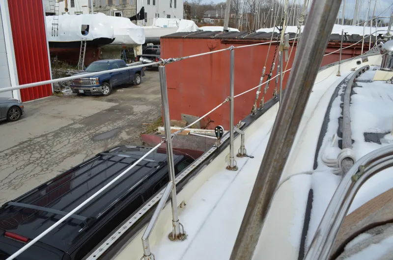 Slide: The Image of 1982 Young Sun Cutter sailboat in a snowy boatyard with covered vessels and parked cars. - 43