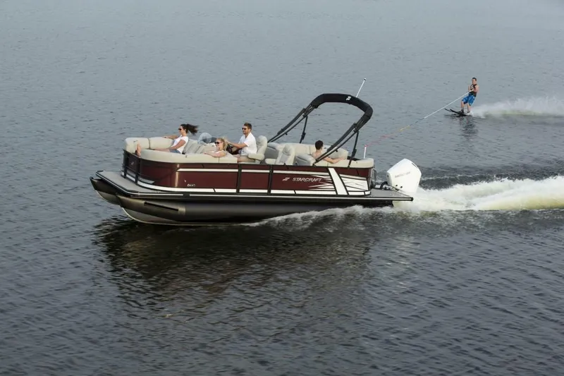 Slide: The Image of 2023 Starcraft SLS 3 pontoon boat with people and a water skier. - 3