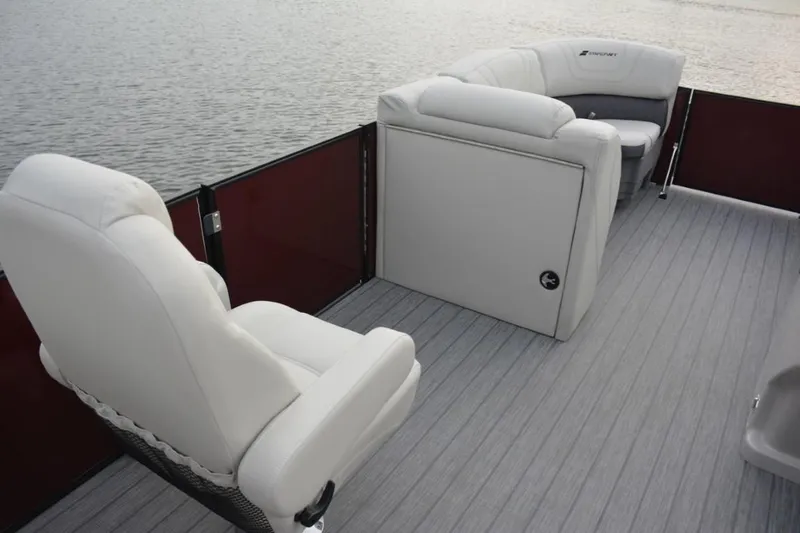 Slide: The Image of 2023 Starcraft SLS 1 pontoon boat with white seating on a lake. - 14