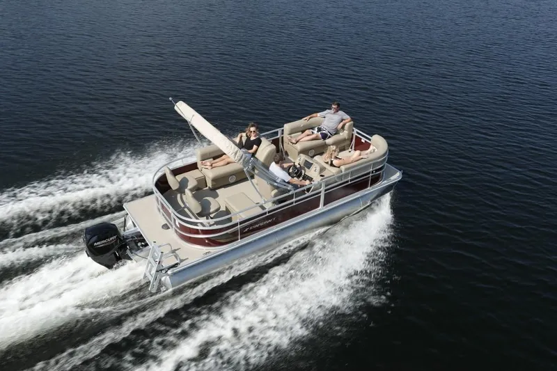 Slide: The Image of 2023 Starcraft LX 20 pontoon boat cruising on a lake. - 6