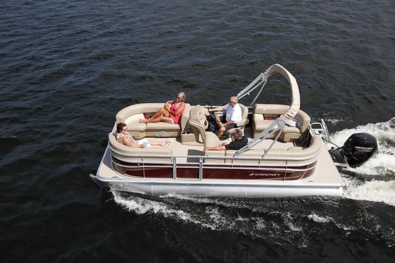 Slide: The Image of 2023 Starcraft LX 18 pontoon boat cruising on the water with passengers. - 1