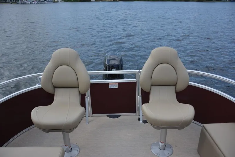 Slide: The Image of 2023 Starcraft LX 18 pontoon boat with beige seats on a lake. - 14
