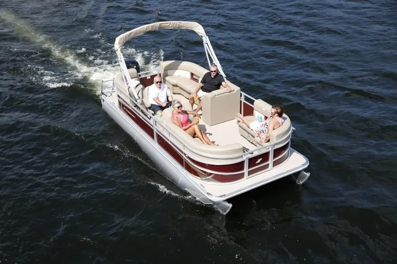 Slide: The Image of 2023 Starcraft LX 18 pontoon boat cruising on the water with passengers. - 3