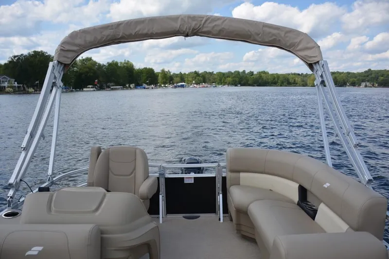 Slide: The Image of 2023 Starcraft LX 16 pontoon boat on a serene lake. - 10