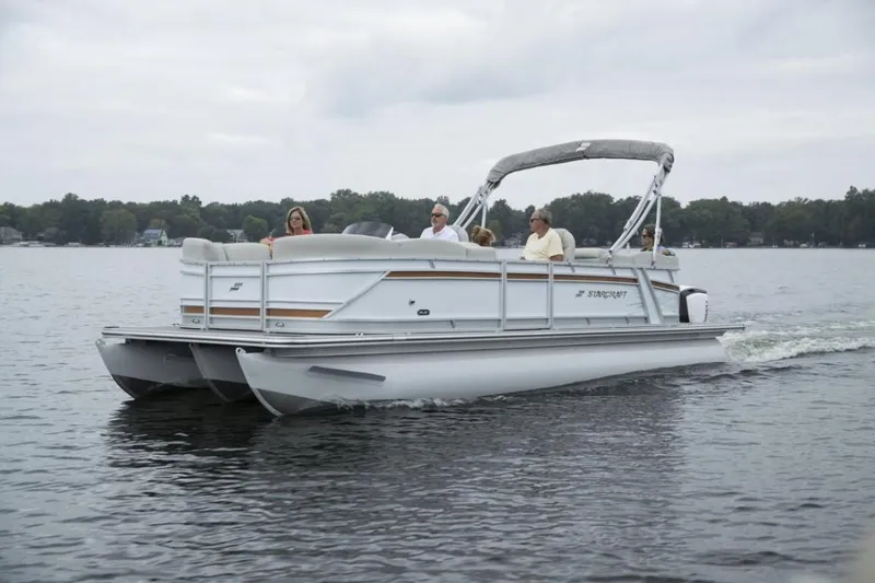 Slide: The Image of 2023 Starcraft SLS 5 pontoon boat cruising on a lake with passengers. - 6