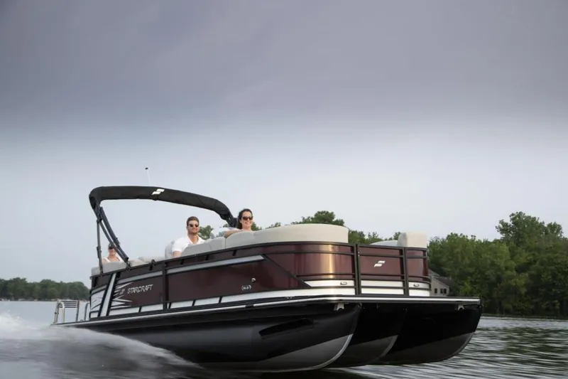 Slide: The Image of 2023 Starcraft SLS 5 pontoon boat cruising on a lake. - 7