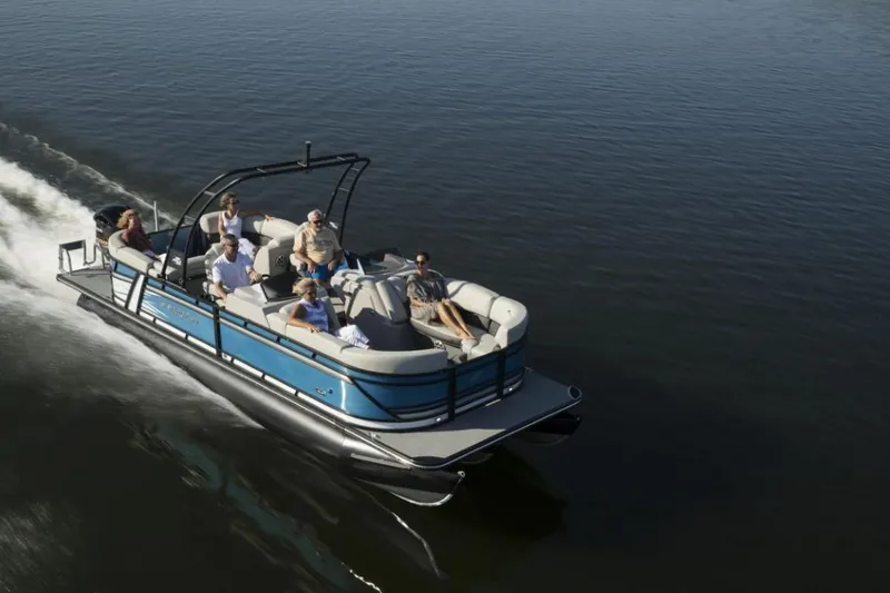 Slide: The Image of 2023 Starcraft SLS 1 pontoon boat cruising on a calm lake with passengers. - 5