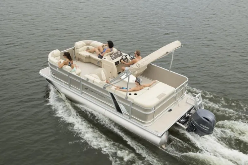 Slide: The Image of 2023 Starcraft EX 24 pontoon boat cruising on water with passengers relaxing. - 4