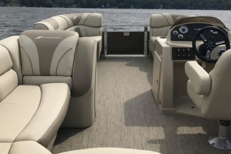 Slide: The Image of 2023 Starcraft EX 24 pontoon boat interior with beige seating and steering console. - 9