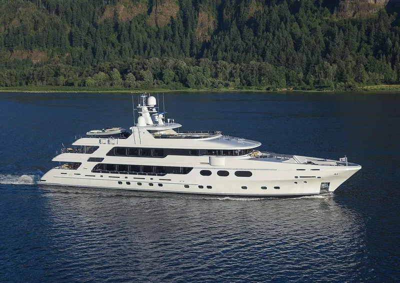 The Image of Christensen Model Year 2020 luxury yacht cruising on a serene lake with forested hills in the background. - 0