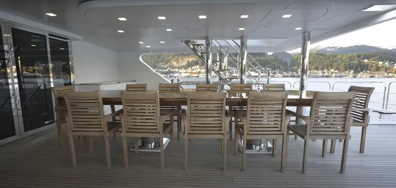 Slide: The Image of Luxury yacht dining area on Christensen Model Year 2020, featuring wooden table and chairs. - 15
