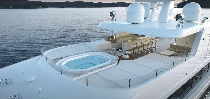 Slide: The Image of Luxurious Christensen 2020 yacht with hot tub and bar on the deck, cruising on serene waters. - 28