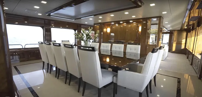 Slide: The Image of Luxurious dining area on Christensen Model Year 2020 yacht with elegant white chairs and wooden accents. - 5