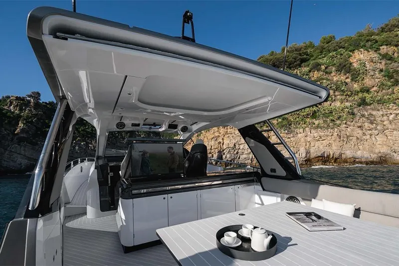 Slide: The Image of 2023 Azimut Verve 47 luxury yacht interior with dining area and scenic coastal view. - 12