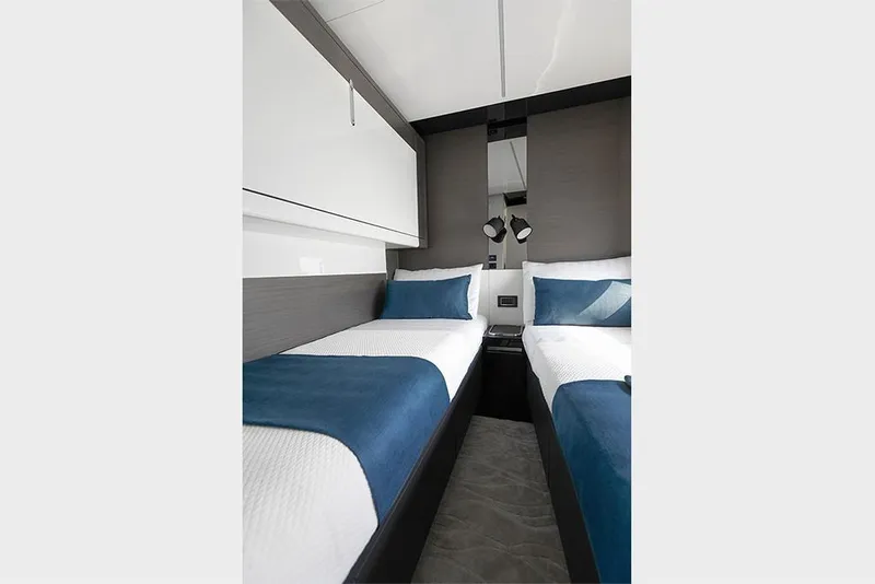 Slide: The Image of 2023 Azimut S8 yacht twin bedroom with modern decor and blue accents. - 19