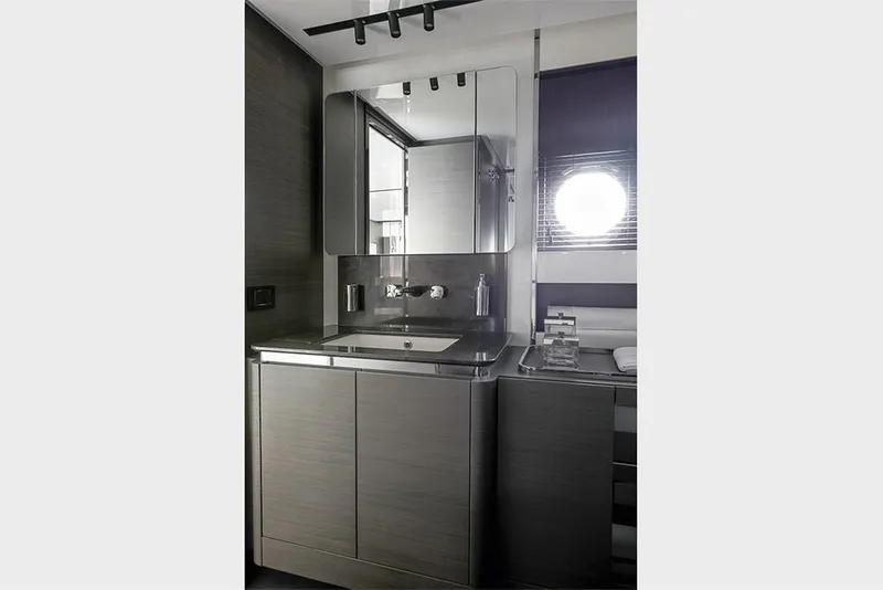 Slide: The Image of Modern bathroom in 2023 Azimut S8 yacht with sleek cabinetry and round porthole window. - 21