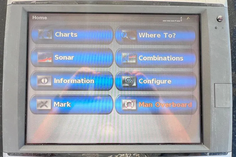 Slide: The Image of Boat navigation system display with options like charts, sonar, and man overboard alert. Intrepid 366, 2002. - 13