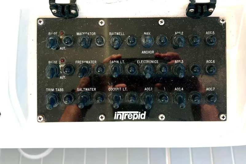 Slide: The Image of Control panel of a 2002 Intrepid 366 boat with various switches and labels. - 14