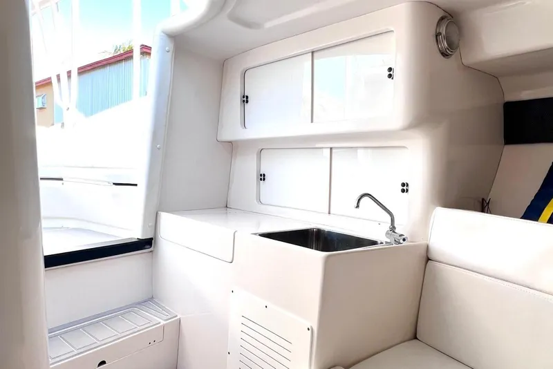 Slide: The Image of Interior of a 2002 Intrepid 366 boat featuring a compact kitchenette with sink. - 17