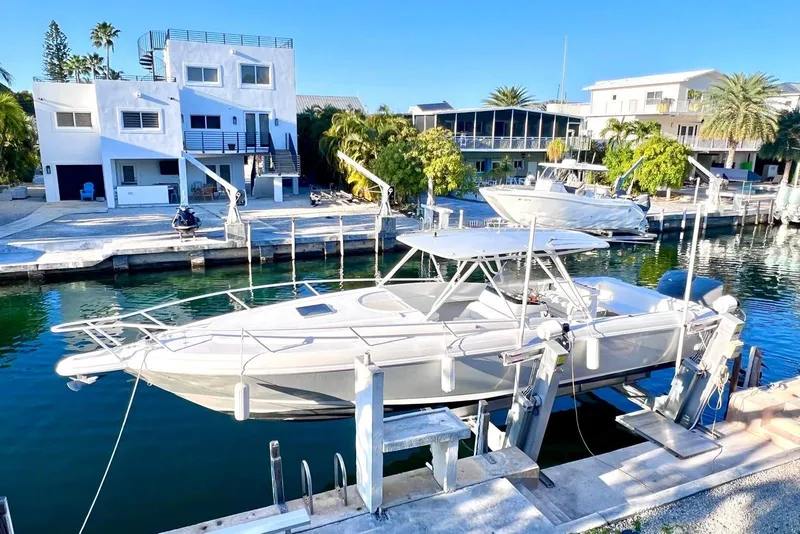 Slide: The Image of 2002 Intrepid 366 boat docked by waterfront homes under clear blue sky. - 3