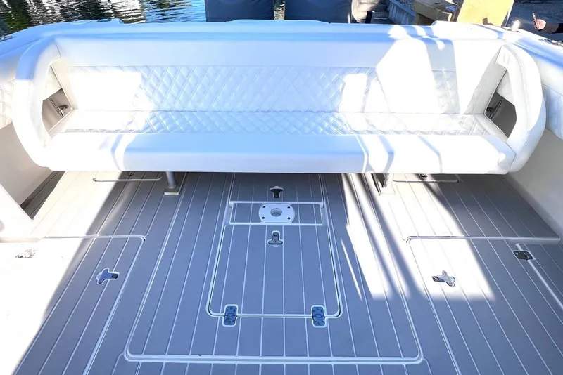 Slide: The Image of 2002 Intrepid 366 boat interior with white cushioned seating and sleek gray flooring. - 7
