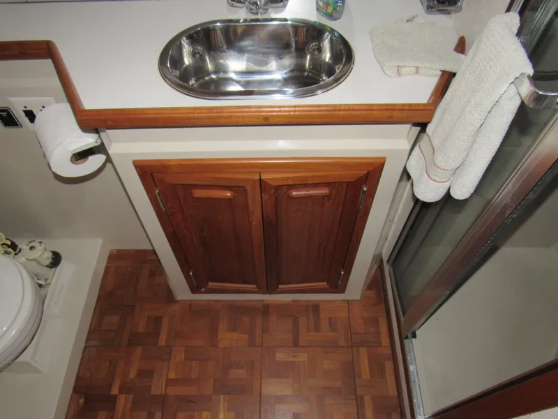 Slide: The Image of Bathroom interior of 1991 Carver 430 Cockpit Motor Yacht with wooden cabinets and sink. - 10