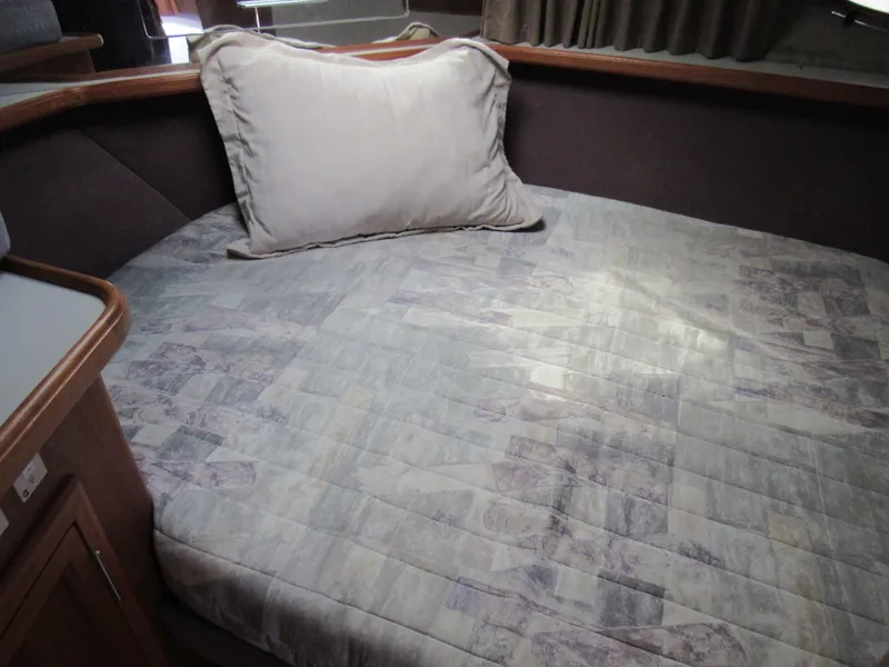 Slide: The Image of 1991 Carver 430 Cockpit Motor Yacht interior with a cozy bed and pillow. - 11