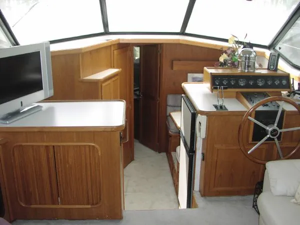 Slide: The Image of Interior of 1991 Carver 430 Cockpit Motor Yacht with helm, TV, and wood cabinetry. - 2