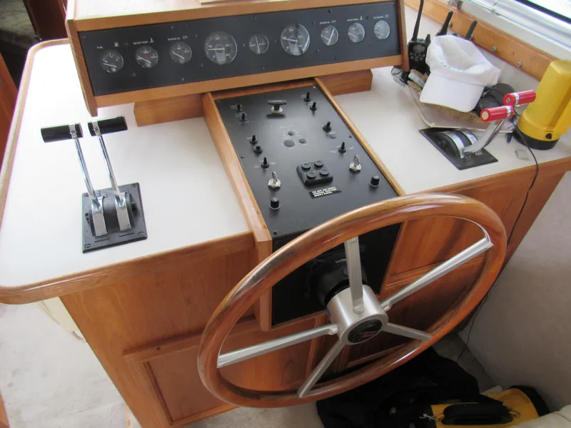 Slide: The Image of 1991 Carver 430 Cockpit Motor Yacht helm with wooden steering wheel and control panel. - 3