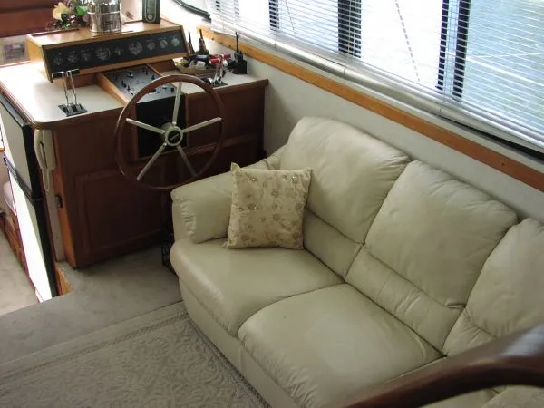 Slide: The Image of Interior of 1991 Carver 430 Cockpit Motor Yacht with helm and beige sofa. - 4