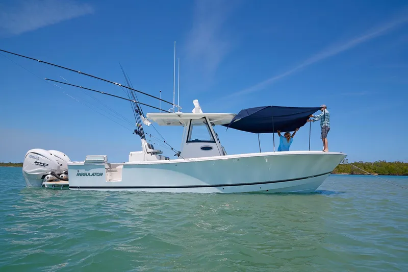 Slide: The Image of 2025 Regulator 31 boat with canopy setup on calm water. - 11