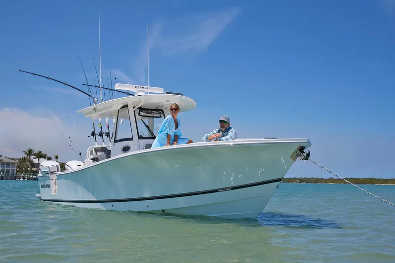 Slide: The Image of 2025 Regulator 31 boat anchored in clear water with two people onboard. - 12