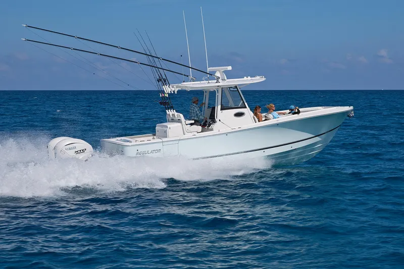 Slide: The Image of 2025 Regulator 31 boat cruising on open ocean with fishing rods and Yamaha engine. - 14