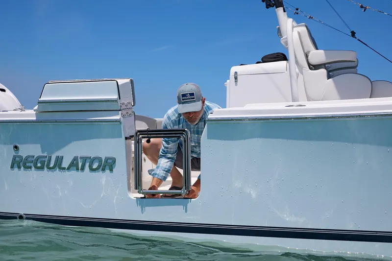 Slide: The Image of 2025 Regulator 31 boat with person accessing side hatch on a sunny day. - 4