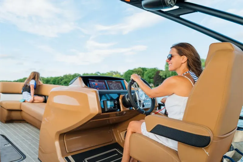 Slide: The Image of Woman driving 2023 Harris Solstice 250 boat with child in the background. - 15