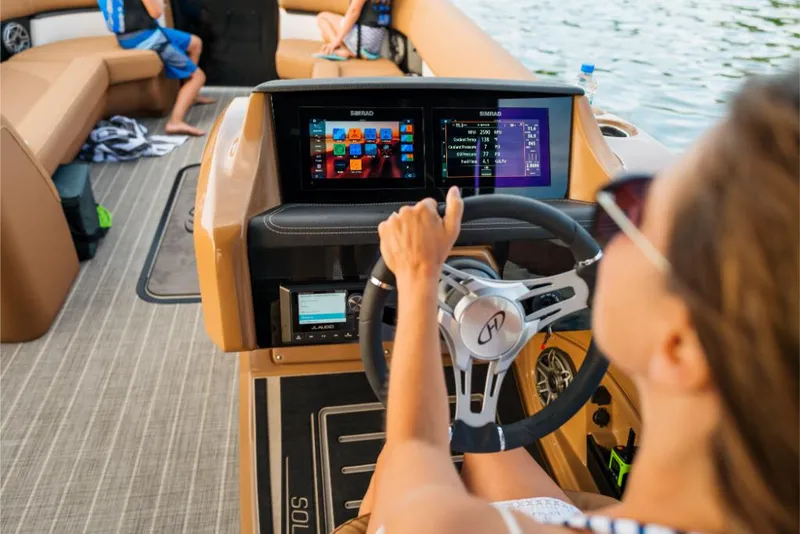 Slide: The Image of 2023 Harris Solstice 250 boat interior with advanced dashboard and passengers. - 16