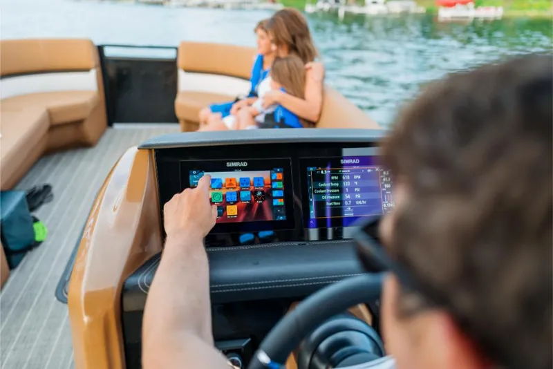 Slide: The Image of 2023 Harris Solstice 250 boat with touchscreen controls and family onboard. - 19