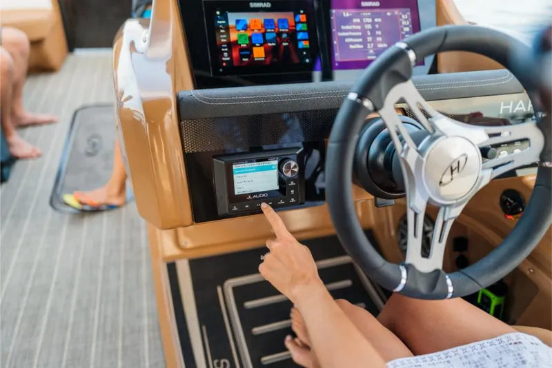 Slide: The Image of 2023 Harris Solstice 250 boat dashboard with touchscreen controls and steering wheel. - 23