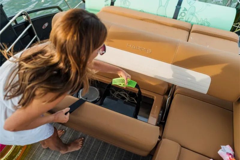Slide: The Image of Woman accessing storage compartment on 2023 Harris Solstice 250 boat. - 5