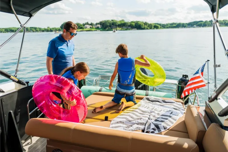 Slide: The Image of Family enjoying a day on a 2023 Harris Solstice 250 pontoon boat with inflatables. - 6