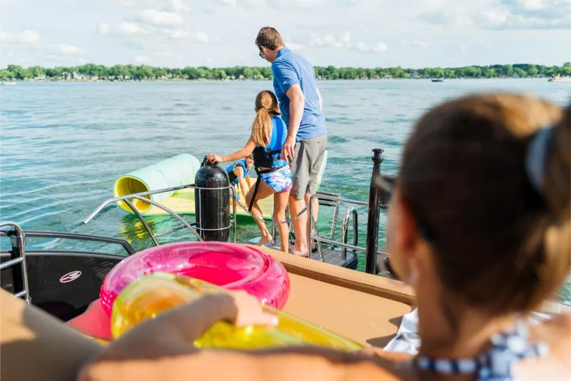 Slide: The Image of Family enjoying water activities on a 2023 Harris Solstice 250 boat. - 7