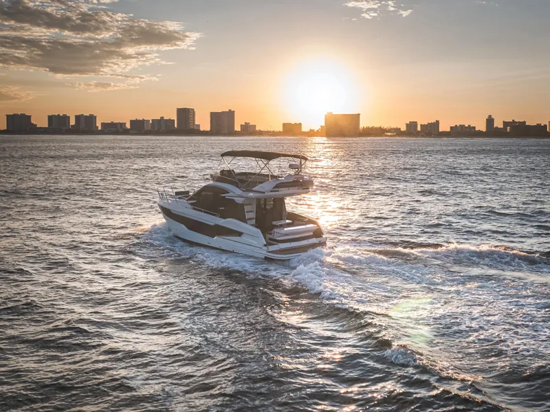 Slide: The Image of Galeon 400 Fly 2023 yacht cruising at sunset near city skyline. - 13