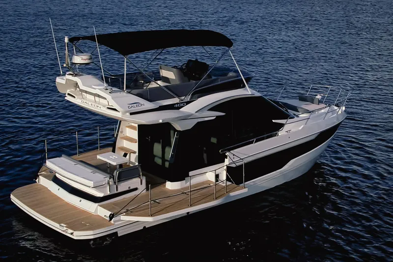 Slide: The Image of 2023 Galeon 400 Fly yacht on calm water, showcasing sleek design and spacious deck. - 15