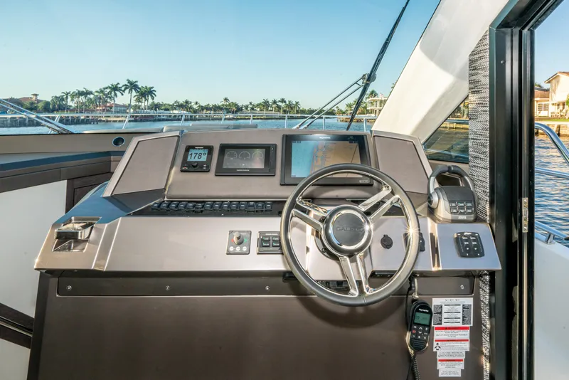 Slide: The Image of 2023 Galeon 400 Fly yacht helm with modern controls and scenic waterfront view. - 24