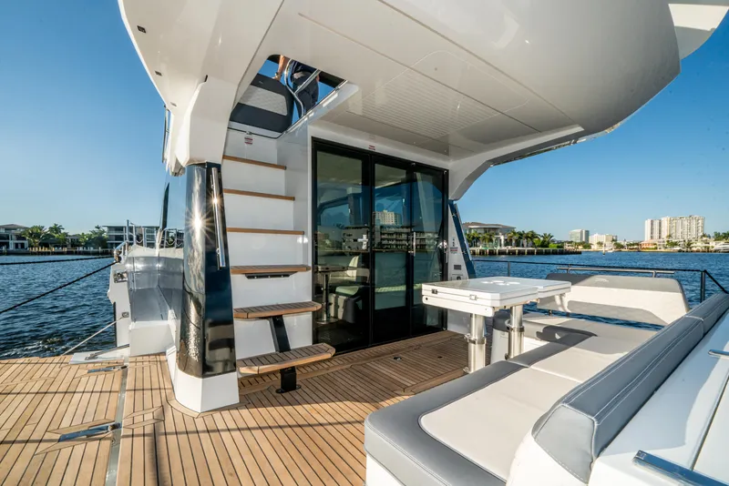 Slide: The Image of 2023 Galeon 400 Fly yacht deck with seating and stairs, overlooking waterfront. - 48