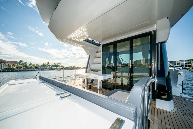 Slide: The Image of 2023 Galeon 400 Fly yacht deck with seating and scenic waterfront view. - 49